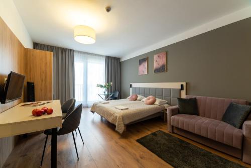 a living room with a bed and a couch at Wolska Residence I in Warsaw