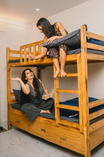 two women sitting on top of a bunk bed at Urban Loft Hostel in Rishīkesh