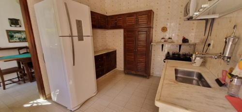 a kitchen with a white refrigerator and a sink at Pousada Pe da Serra in Tiradentes