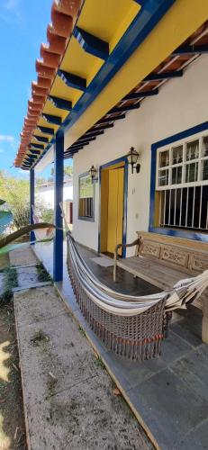 a porch with a hammock outside of a building at Pousada Pe da Serra in Tiradentes