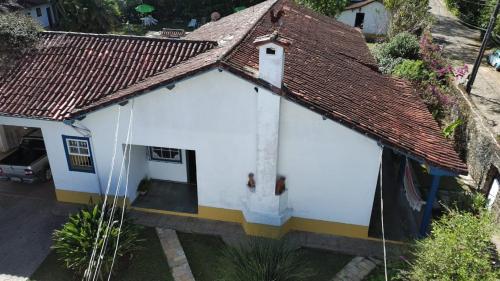 a small white house with a brown roof at Pousada Pe da Serra in Tiradentes