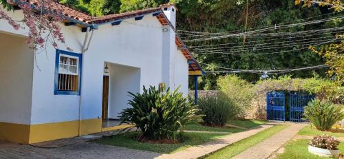 a white house with a yellow and blue at Pousada Pe da Serra in Tiradentes