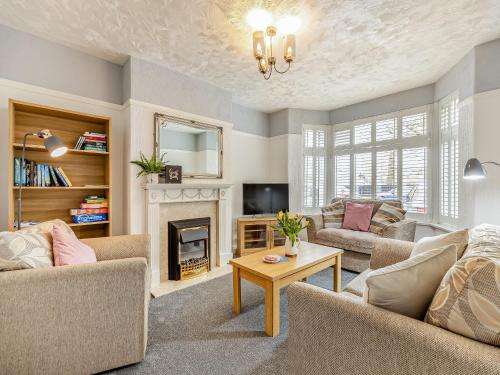 a living room with two couches and a fireplace at Cherry Blossom in Skegness