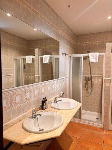 a bathroom with two sinks and a shower at CASA RURAL Cigarral del Pintor in Toledo