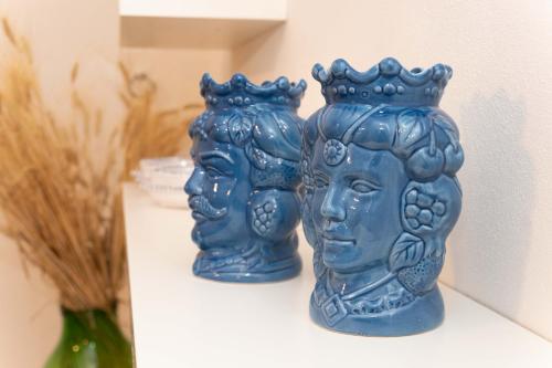 two blue vases are sitting on a shelf at Villa dei Mandorli in Naro