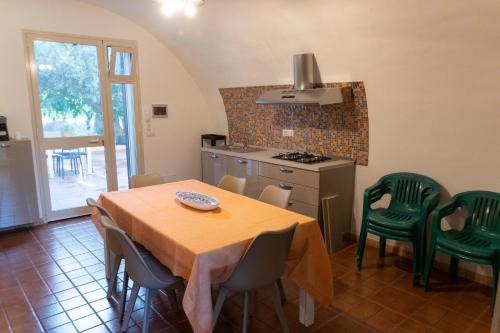 a kitchen with a table and chairs and a kitchen with a stove at Villa dei Mandorli in Naro