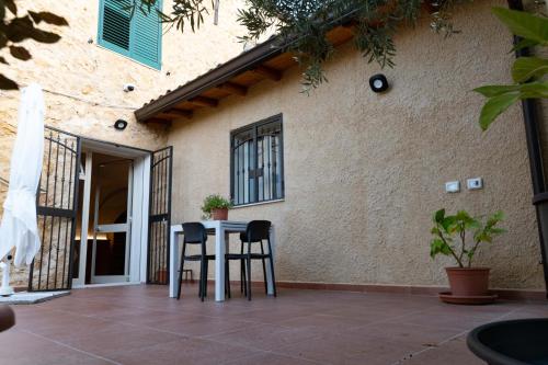 a table and two chairs in front of a building at Villa dei Mandorli in Naro