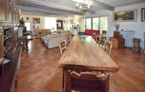 una gran sala de estar con mesa de madera y sillas. en Maison Avec Piscine Privée, en Malaucène