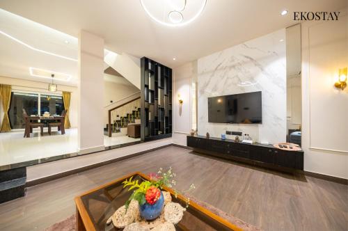 a large living room with a tv and a table at EKOSTAY - Amber Villa in Kodaikānāl