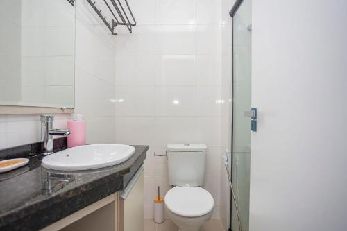 a bathroom with a toilet and a sink at MUV proximo ao shopping in Curitiba