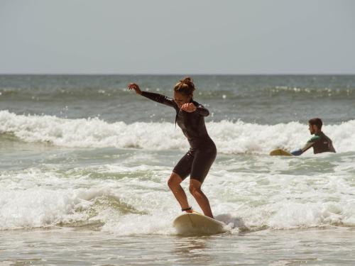 a woman riding a wave on a surfboard in the ocean at Tombo Beach in Guarujá