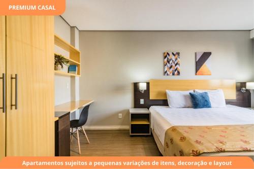a hotel room with a bed and a desk at Century Park by My Way in Porto Alegre
