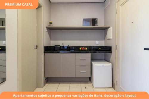 a small kitchen with a sink and a refrigerator at Century Park by My Way in Porto Alegre