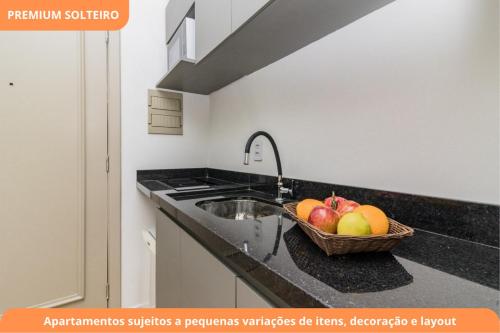 a kitchen with a sink and a basket of fruit at Century Park by My Way in Porto Alegre