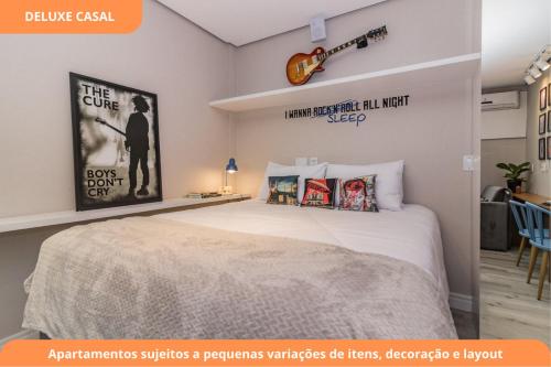 a bedroom with a large white bed with posters on the wall at Century Park by My Way in Porto Alegre