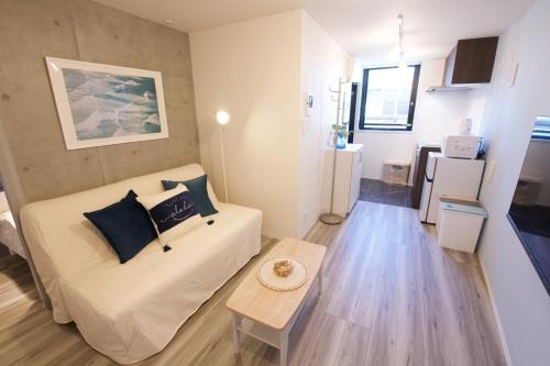 a living room with a couch and a table at TOMALCO INN NAKANO 2 3F Flat 2 Bath 13 min to Shinjuku from Honancho in Tokyo