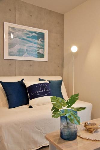 a bedroom with a white bed with blue pillows at TOMALCO INN NAKANO 2 3F Flat 2 Bath 13 min to Shinjuku from Honancho in Tokyo