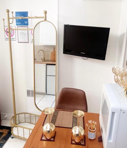 un salon avec une table et une télévision dans l'établissement Sympathy Studio For 2 Near The Sacre Coeur, à Paris