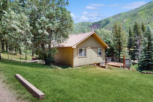 a small house in the middle of a field at Elephant Mountain Cabin at Filoha Meadows in Redstone