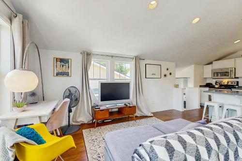 a living room with a couch and a tv and a table at New Portland Neighborhood Studio in Portland