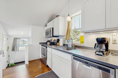 a kitchen with white cabinets and a stainless steel sink at New Portland Neighborhood Studio in Portland