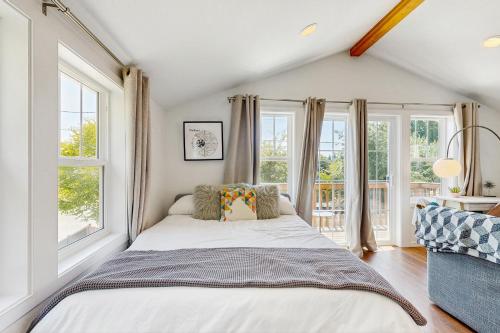 a bedroom with a large bed and windows at New Portland Neighborhood Studio in Portland