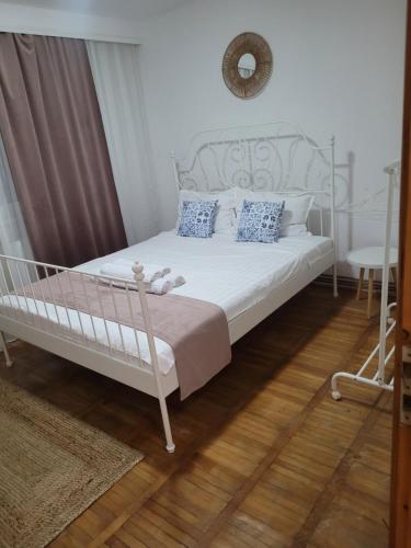a bedroom with a white bed with a metal frame at La Mare Apartments - 25 in Constanţa