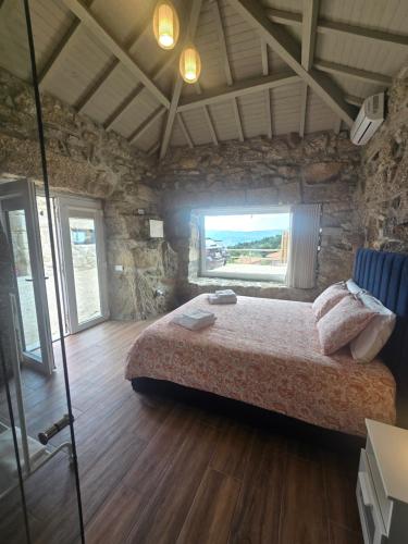 a bedroom with a large bed in a stone room at Casa Vale do Luar in Celorico de Basto