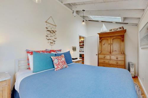 a bedroom with a blue bed and a wooden cabinet at Mar-Tiny in Bodega Bay