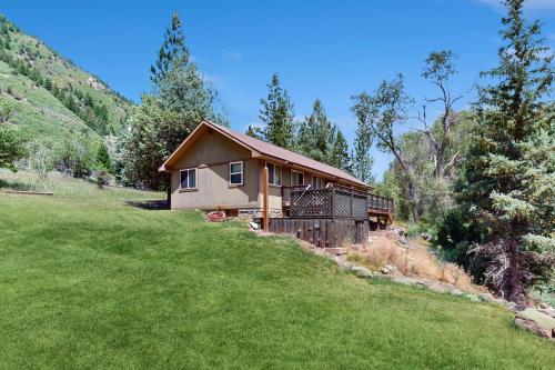 a house on a hill with a green field at Elephant Mountain Cabin at Filoha Meadows in Redstone