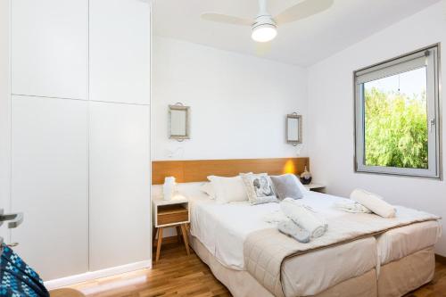 a white bedroom with a large bed and a window at Extraordinary Rethymno Villa Villa Hantengu 3 Bedrooms Beach Front Private Outdoor Swimming Pool And Hot Tub Pigianos Kampos in Pigianos Kampos