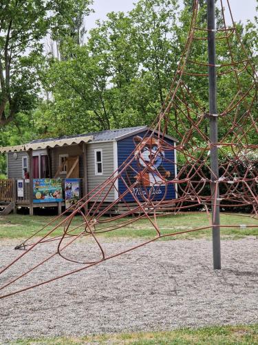 a child on a swing in front of a caravan at Mobil home en Provence - Camping 4 étoiles- 2 chambres -4 à 6 pers-clim-terrasse-TV in Cadenet
