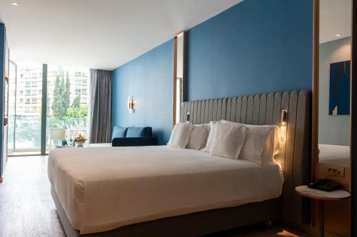 a bedroom with a large bed with a blue wall at Barceló Tanger in Tangier