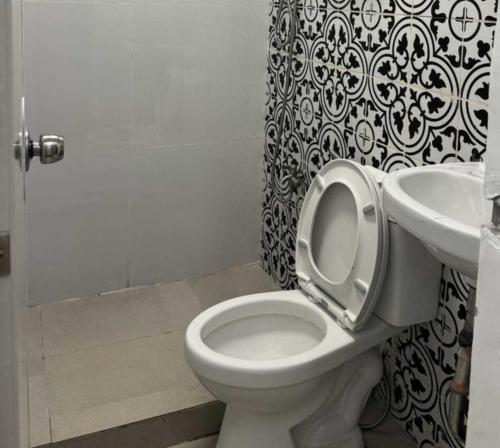 a bathroom with a toilet and a sink at OYO 1155 Carnivale Inn in Manila
