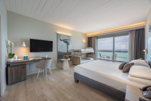 a hotel room with a bed and a desk and a television at Nautilus Family Hotel in Pesaro