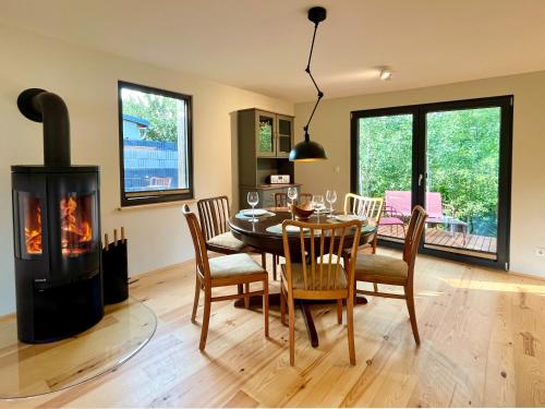 a dining room with a table and a wood stove at Haus 2 am Grimnitzsee - hochwertiges Design, mit eigenem Garten und nah am See in Joachimsthal