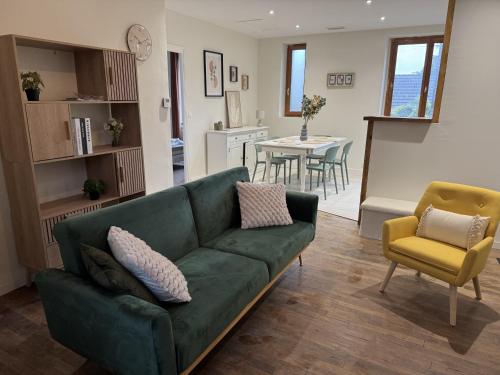 a living room with a green couch and a dining room at La Villa Pagnon - 3 Chambres in Brive-la-Gaillarde