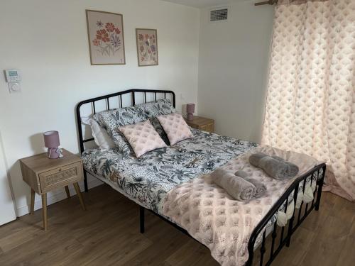 a bedroom with a bed with pillows on it at La Villa Pagnon - 3 Chambres in Brive-la-Gaillarde