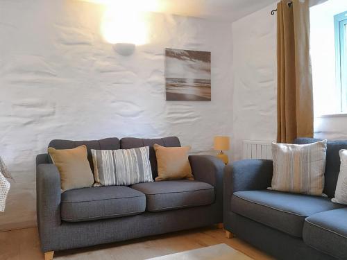 a living room with two chairs and a couch at Oak Barn in Porthtowan