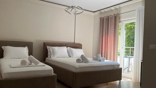 a bedroom with two beds and a window at Hotel DEMOLI in Pogradec