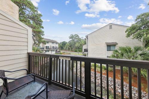 a balcony with a bench and a house at Forest Beach Villa - 2 BDR for 6 in Hilton Head Island