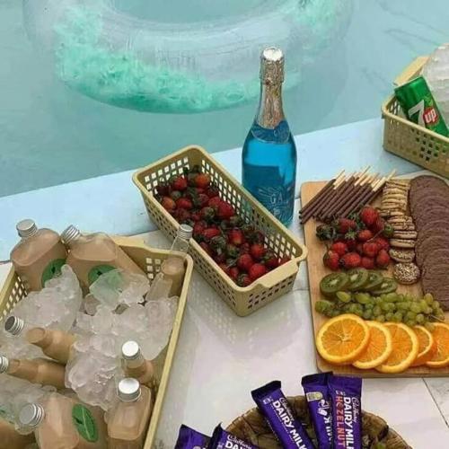 a table with baskets of fruit and a bottle of water at كمباوند شاليهات فابيلوس 