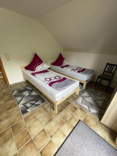 two beds in a small room with a chair at Zimmer in Lautrach in Lautrach
