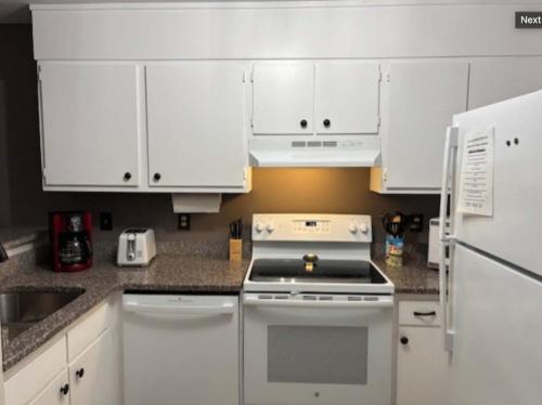 a kitchen with white cabinets and a stove top oven at Resort Condo for 6 with Tons of Amenities Near Beach in Hilton Head Island