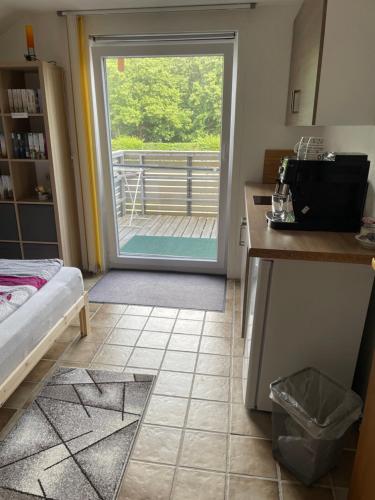 a kitchen with a door leading to a balcony at Zimmer in Lautrach in Lautrach