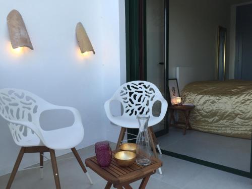 Habitación con 2 sillas blancas y 1 cama en Apartment Joaquin, en Frigiliana