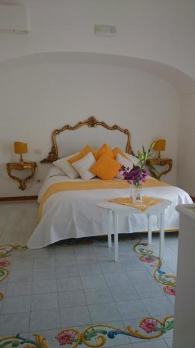 a bedroom with a bed and a table with flowers on it at Villa Yiara in Positano
