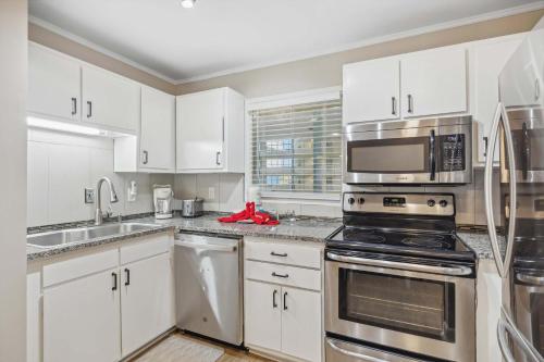 a kitchen with white cabinets and stainless steel appliances at Ocean Breeze - Island Retreat for 6 in Hilton Head Island