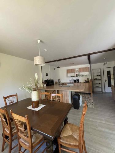 une salle à manger et une cuisine avec une table et des chaises dans l'établissement Gîte du RELAI du Château - Parc Oriental - Puy du Fou, à La Tourlandry
