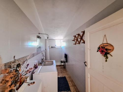 a white bathroom with a sink and a door at Masseria PietraViva in Altamura